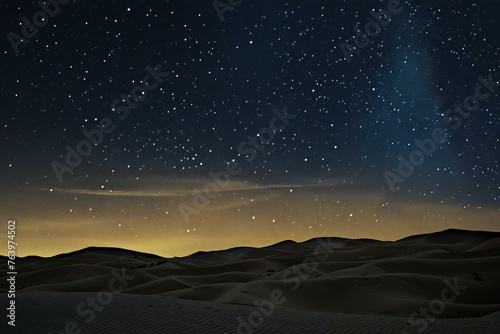 Stars in the night sky over sand dunes