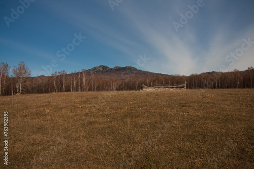 Blurred natural landscape with grassy field and mountain silhouette