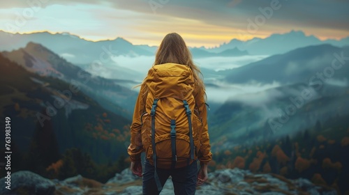 a woman standing on a rock looking at a valley