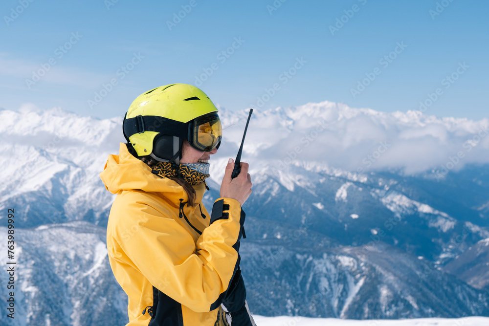 Female snowboarder using walkie-talkie in high mountains, extreme winter sport outdoor