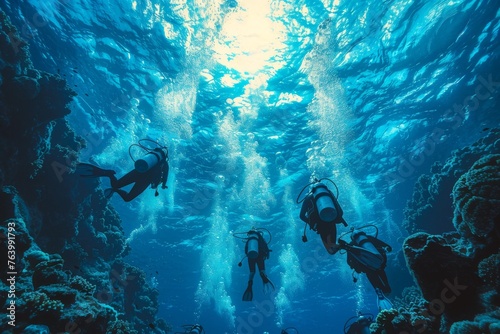 A group of scuba divers is seen exploring the majestic coral reef in the deep azure ocean  with sunlight filtering from above