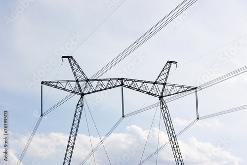 Electric poles with wires against the sky with clouds. The idea of providing electricity to the population. High quality photo