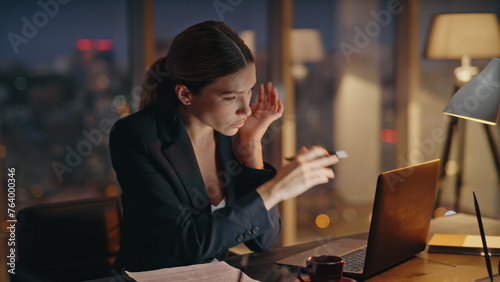 Sleepless businesswoman overwork alone in dark office. Corporate manager typing