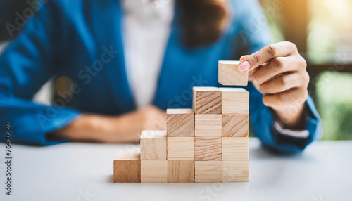 hand arranging wooden blocks, depicting business growth and success process