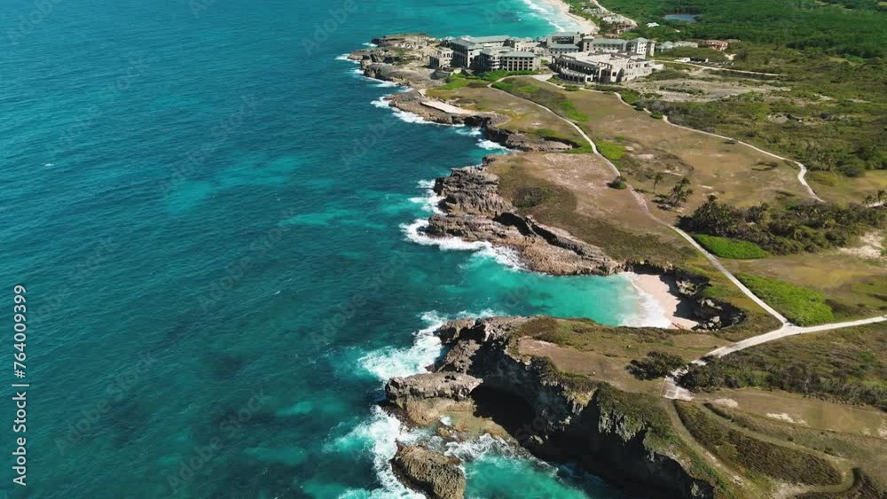 Area view of Colorful waters of the ocean, swirl around the rocky and scenic coastline. Sea waves breaking over rocks.