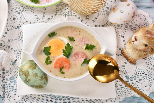 Top view of traditional Easter white borscht with sausage, egg and vegetables