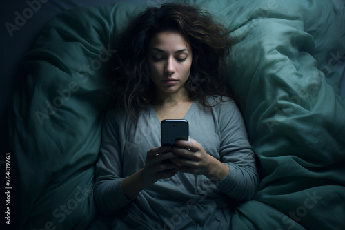 A woman sits in bed at night, staring at her smartphone, reflecting the concepts of insomnia, depression, and anxiety.