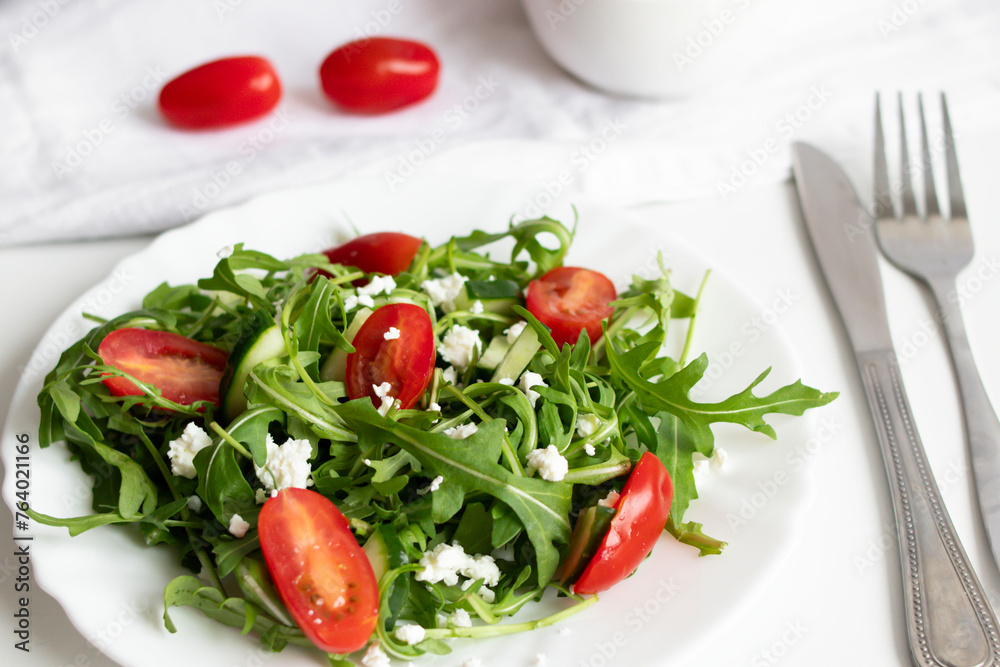 Green vegan salad with arugula leaves and cherry tomatoes. Snack, food Green vegan salad with arugula leaves and cherry tomatoes. Snack, food