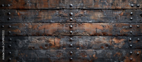 A detailed closeup of a hardwood plank wall with metal rivets, showcasing the intricate pattern and texture of the composite material photo