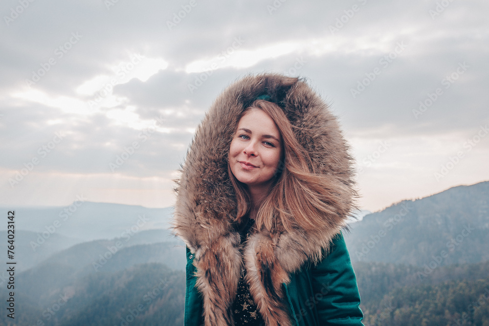 Mountain Chic: Portrait of a Girl in a Furry Jacket amidst the Mountains Mountain Chic: Portrait of a Girl in a Furry Jacket amidst the Mountains