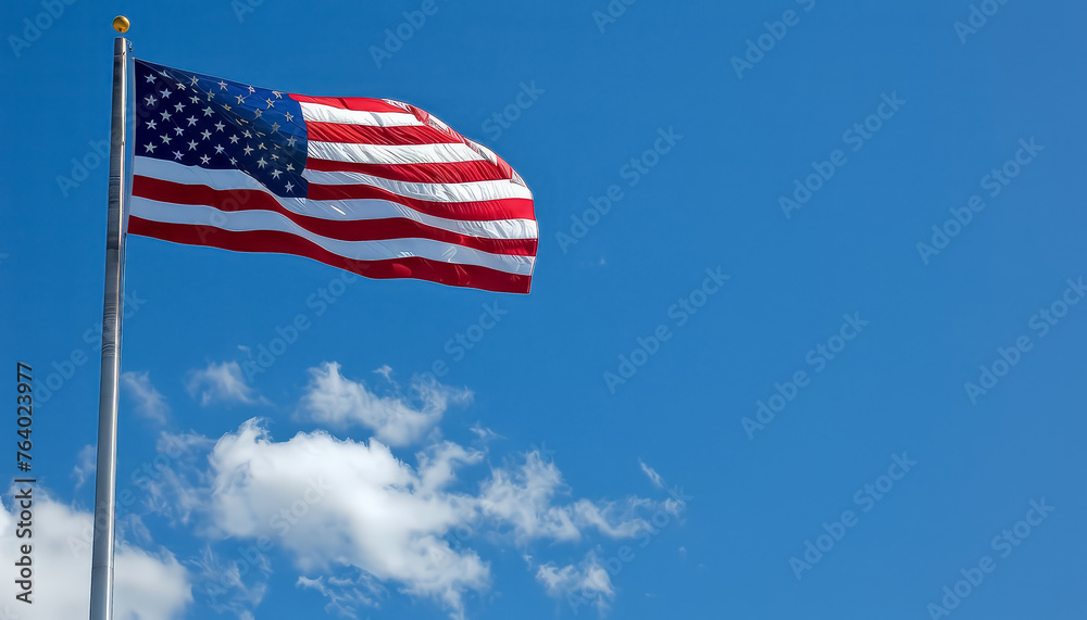 A large American flag is flying high in the sky