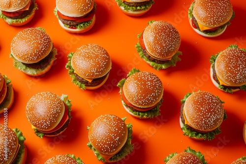 Wallpaper with a bunch of burgers on orange background. Lots of tasty burgers, yummy screen saver. Fast food backdrop. © STOCKAI