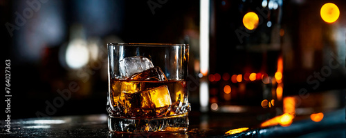 Single whiskey glass with ice on a bar, ambient lighting with reflections, perfect for connoisseur and nightlife themes. photo