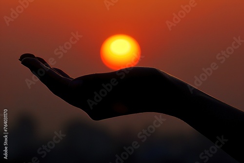 A hand holding a sun in the sky