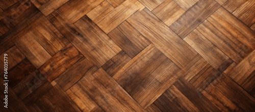 A closeup of a hardwood flooring with a herringbone pattern in brown wood stain. The planks are made of beige plywood with a shiny varnish