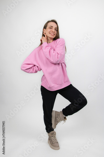 Smiling sportswoman with long hair in a good mood posing, studio shot