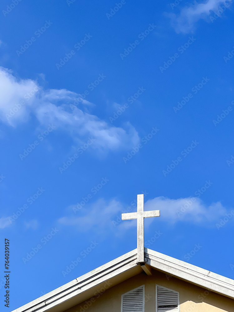 Cross over the church with blue sky.