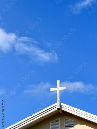 Cross over the church with blue sky.