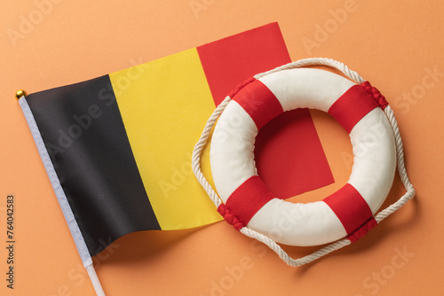 Belgium flag and lifebuoy on color background, concept on aid theme, top view
