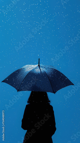 Silhouette of person holding umbrella under stars - A mysterious silhouette of a person holding an umbrella glistens with raindrops under a starry night sky