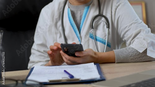 Female doctor using mobile phone close up