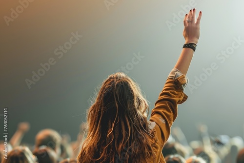 An enthusiastic fan's raised hand captures the atmosphere and energy of a live concert event