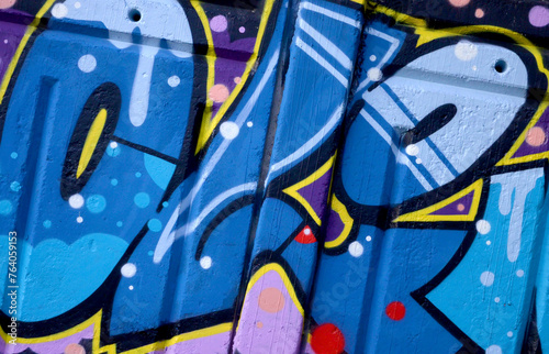 Colorful background of graffiti painting artwork with bright aerosol outlines on wall. Old school street art piece made with aerosol spray paint cans. Contemporary youth culture backdrop