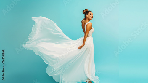 Noiva feliz de vestido branco isolada no fundo azul photo