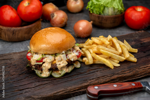 variety of homemade beef burgers with onion cucumber dressings tomato chedar cheese lettuce mayonnaise mustard ketchup barbecue with potato bun and french fries on wooden board photo