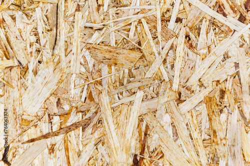 Particleboard close-up texture, abstract background. OSB sheet made from compressed brown wood chips