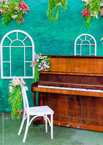 Decorated area for taking photos and videos with piano and white chair, decorated with flowers photo