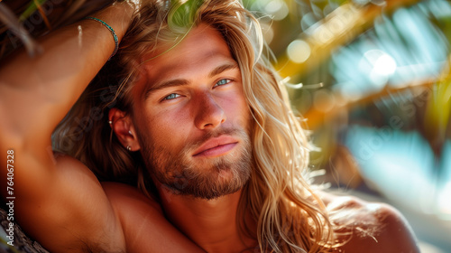 Portrait of a blond man with long hair, beach in the background