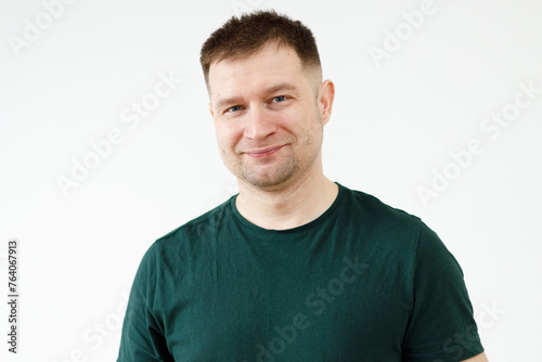 A man in a green T-shirt shows emotions in front of the camera