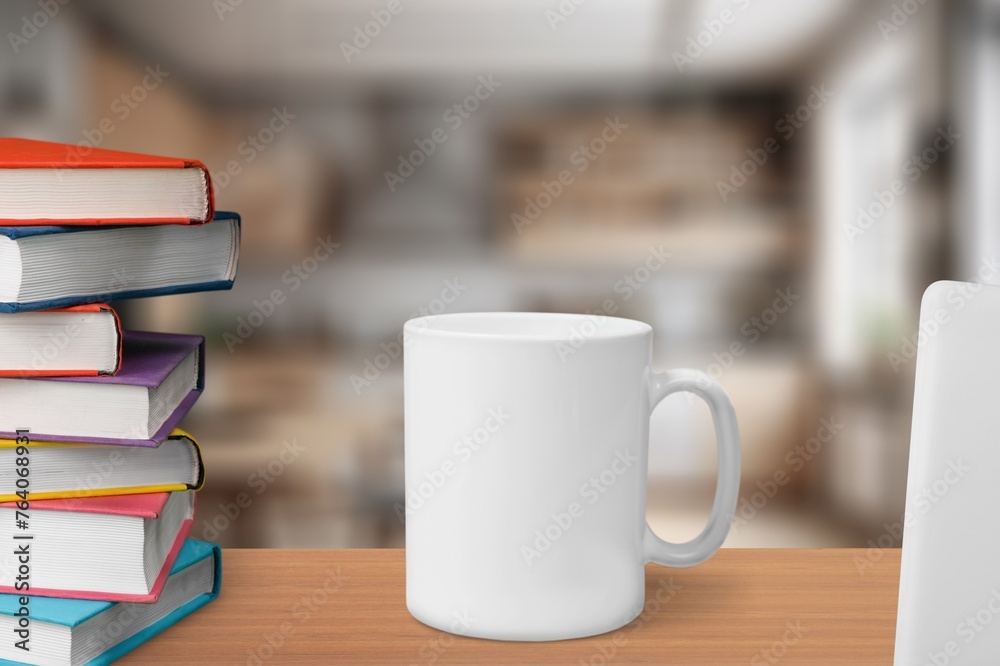 White ceramic cup and notebooks on table White ceramic cup and notebooks on table