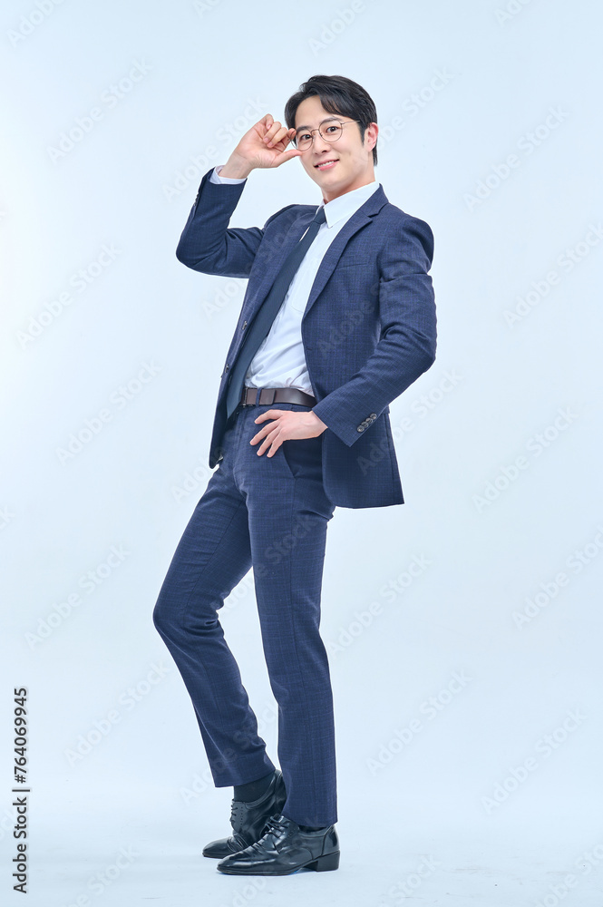 A young office worker man wearing a suit and glasses is posing with various facial expressions. A young office worker man wearing a suit and glasses is posing with various facial expressions.
