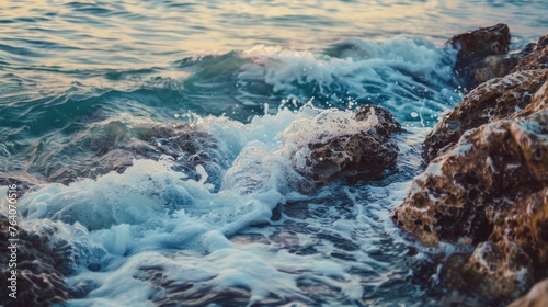 Gentle waves splashing against rocks at sunset