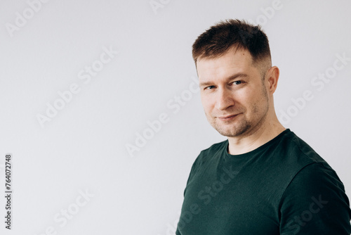 A man in a green T-shirt shows emotions in front of the camera