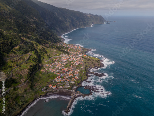 Aerial view of Seixal, a little village by the ocean with waves and surrounded with incredible mountains on the island of Madeira, Portugal.