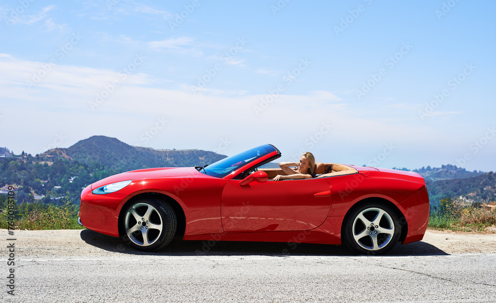 Woman, red convertible and road trip on mountain, travel and luxury transport on summer drive. Happy female person, holiday and countryside wellness on street, vacation and adventure in vehicle