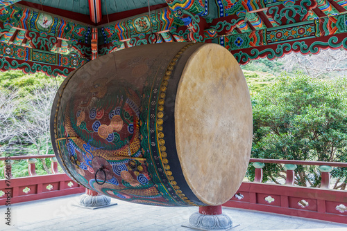 A big drum hangs from the bell tower of a traditional Korean temple.