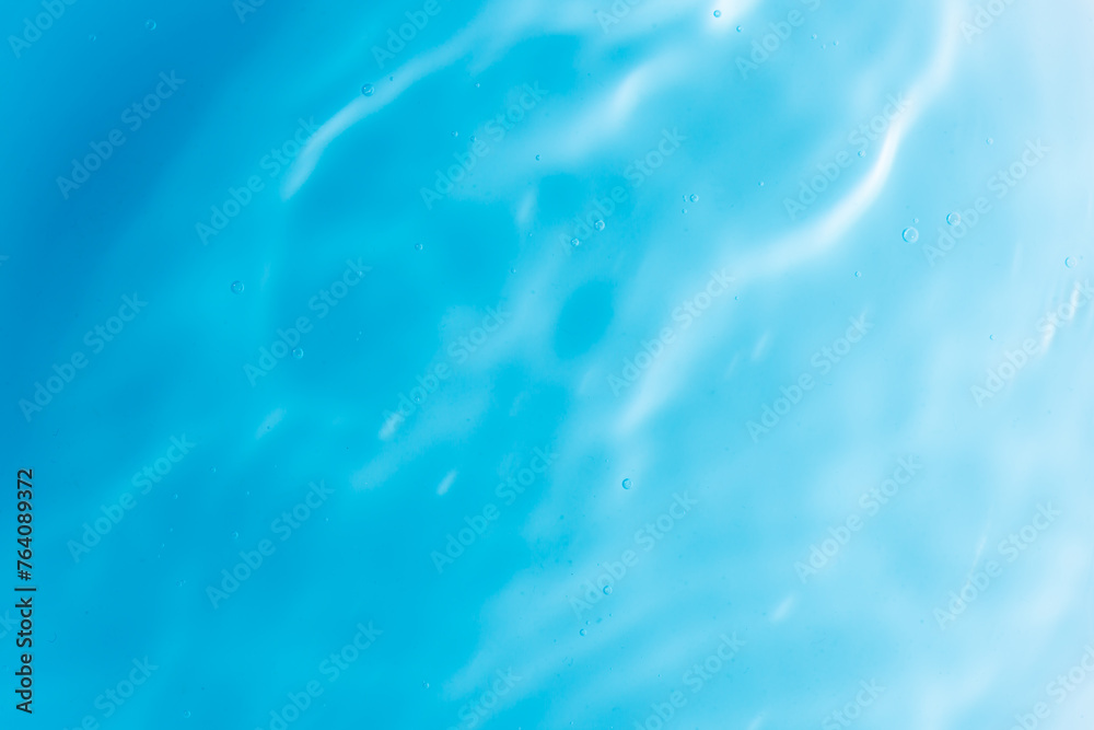 Blue water surface,Transparent blue clear water surface texture with ripples, splashes and bubbles. Abstract nature background Water waves in sunlight. Cosmetic moisturizer micellar toner emulsion. Blue water surface,Transparent blue clear water surface texture with ripples, splashes and bubbles. Abstract nature background Water waves in sunlight. Cosmetic moisturizer micellar toner emulsion.