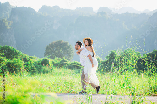 Man carries his girlfriend on his back,Young couple surrounded by mountains and nature,Young couple proposes marriage,Surrounding stunning scenery with views of mountains and valleys