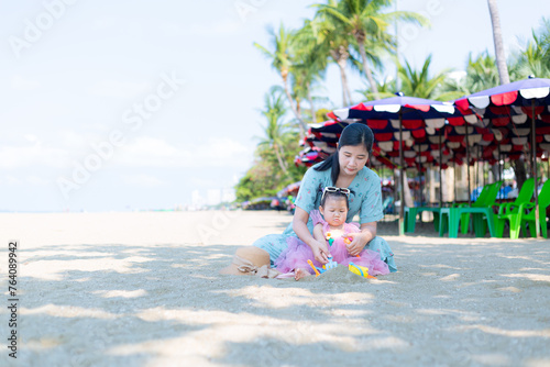 Mother and girl playing in the sand on the beach, Pattaya, Thailand,Mother with children playing with sand on beach