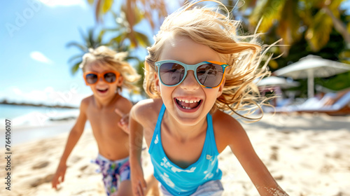 Joyful Caucasian Siblings with Sunglasses girl and boy Playing and running on the exotic Beach on Sunny Day