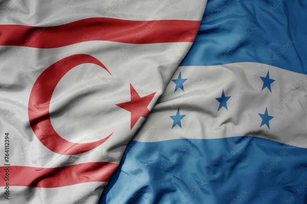 Obraz premium big waving national colorful flag of honduras and national flag of northern cyprus.
