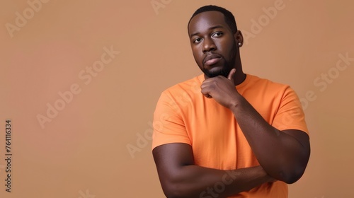 Contemplative young man with a thoughtful expression, looking upward in curiosity against a warm orange backdrop - AI generated.