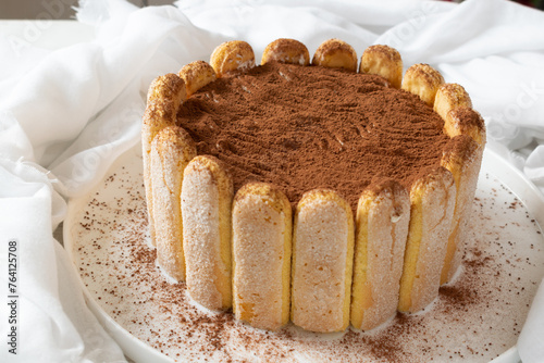 Tableau sur toile Tiramisu cake with a rim of ladyfingers or savoiard biscuits an white background