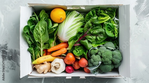 The white box contains baby spinach, garlic, carrots, broccoli, ginger, red cabbage, avocado, banana, mushrooms, lemon, beetroot. and lettuce Side view of the box