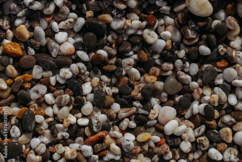 Sea stones of different colors on the shore in close-up 