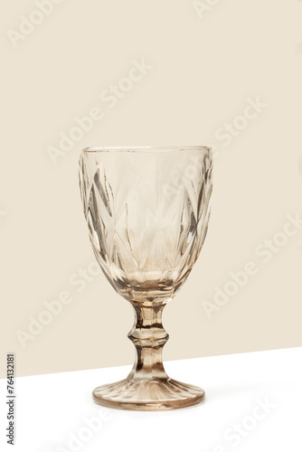 Copa de cristal sobre un fondo beige y blanco. Vista de frente y de cerca. Copy space. Formato vertical